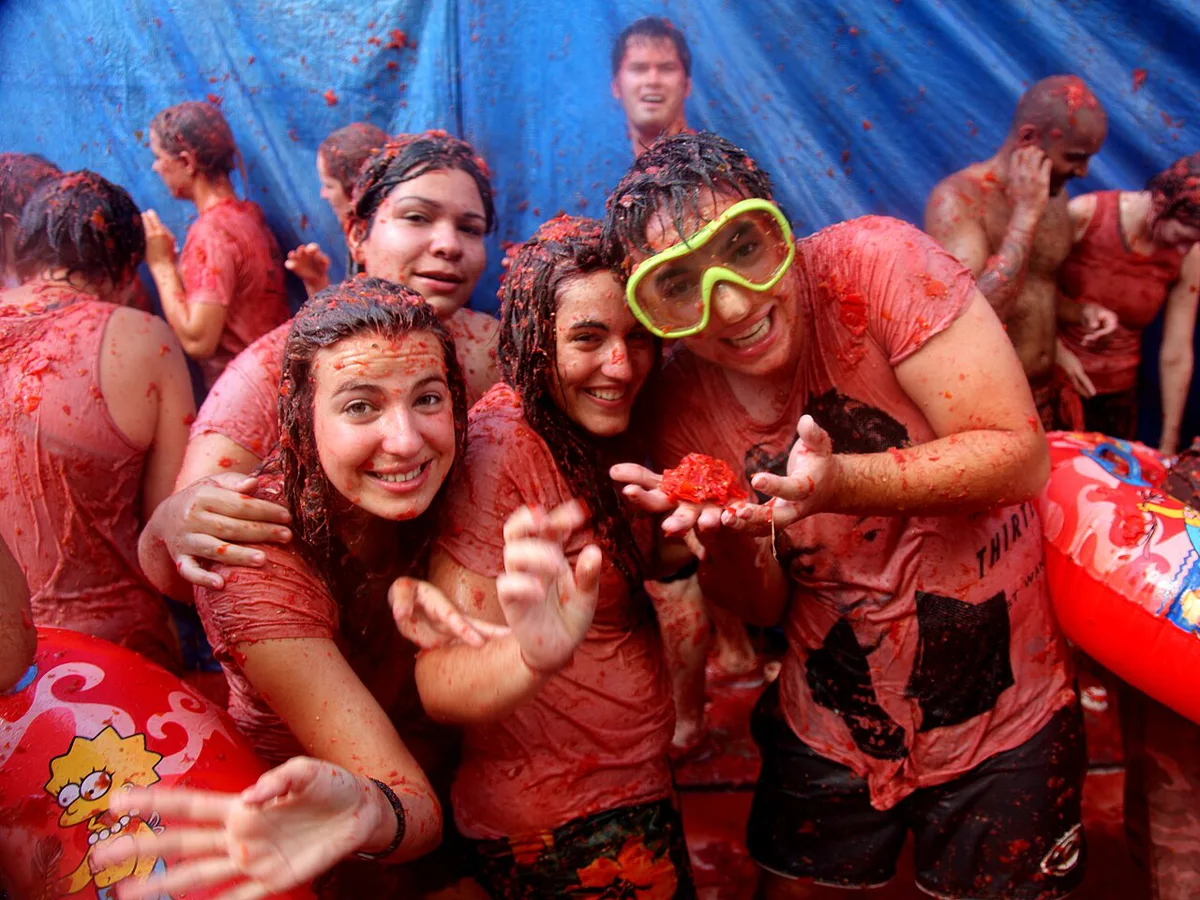 Crowds drenched in tomato pulp in a narrow Bunol street during La Tomatina — 2