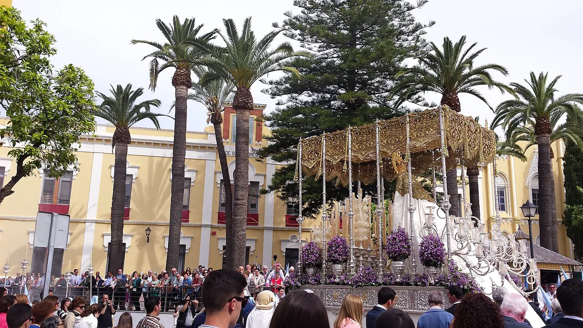 A candlelit Semana Santa float carried through a narrow Seville street at night — 1