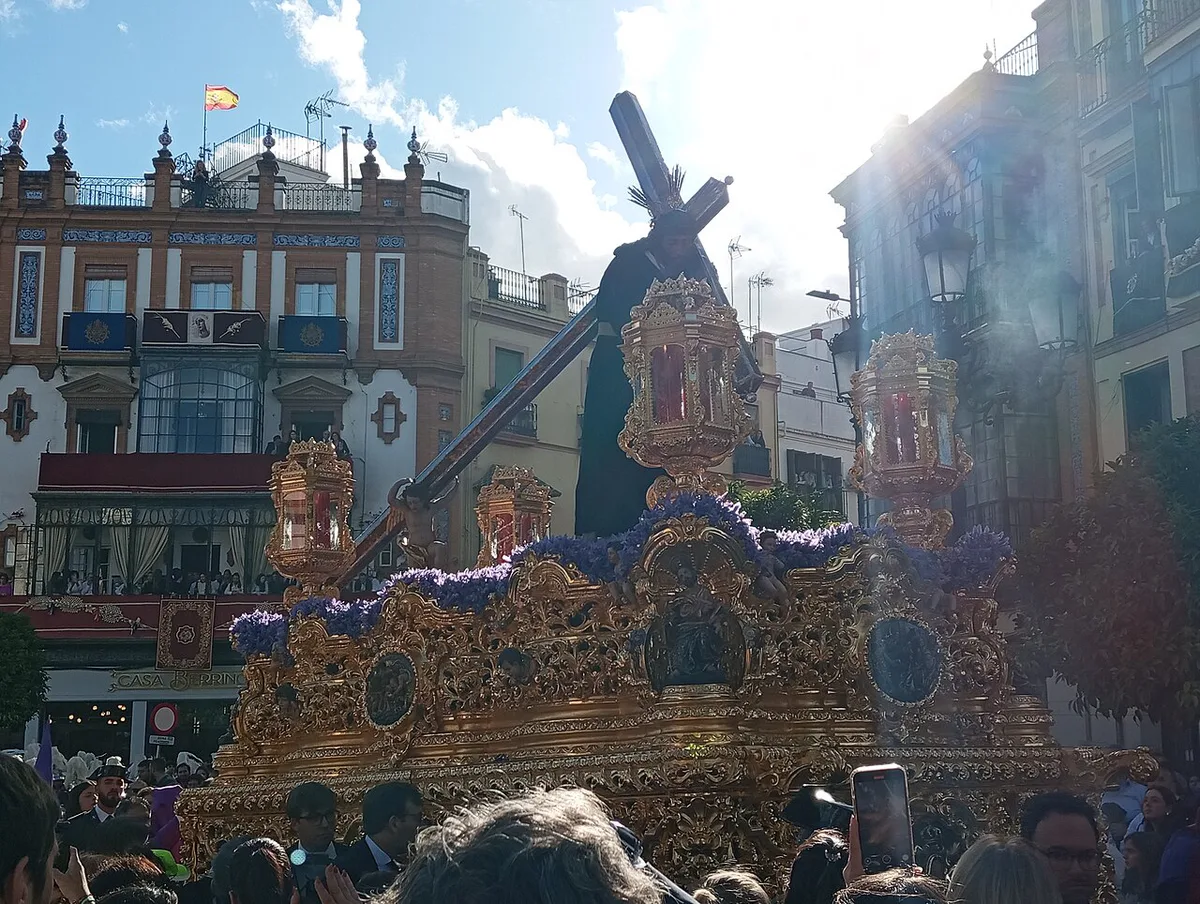 A candlelit Semana Santa float carried through a narrow Seville street at night — 2